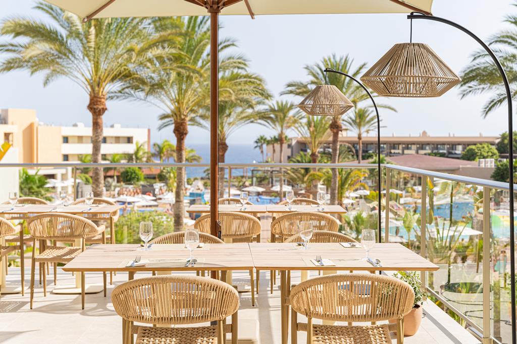 Zonnig terras met uitzicht op resort en zwembad